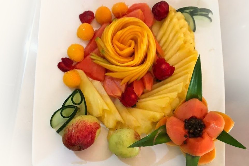 A platter of carved tropical fruit, sliced for small hands