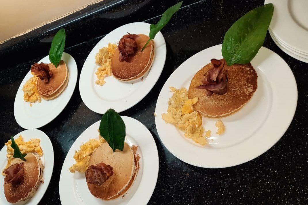 Plated starters lined up on a granite kitchen counter
