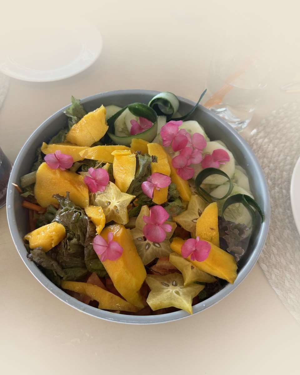 A salad of mango, starfruit and cucumber with edible flowers